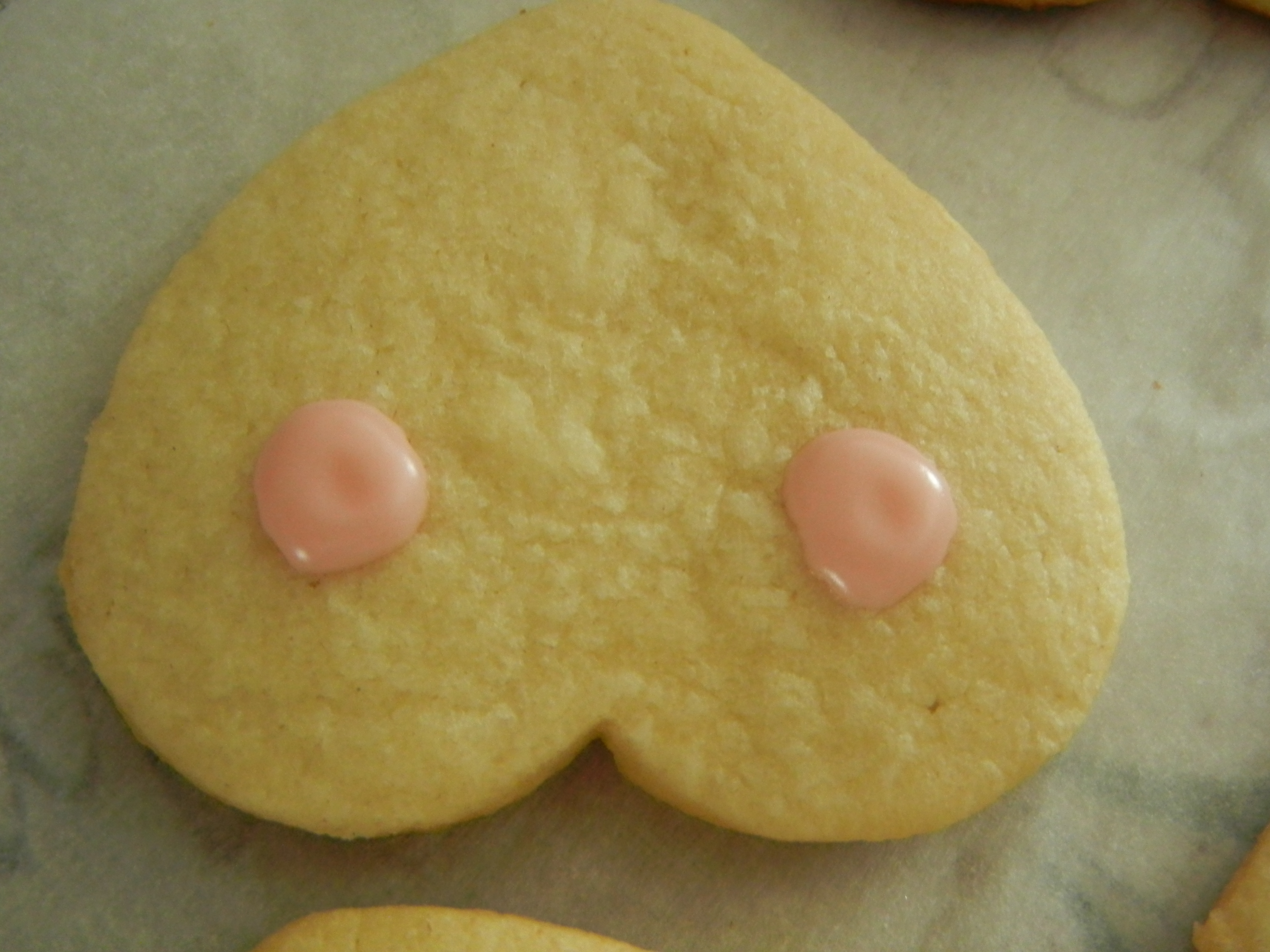 Cut cookies of a boob with nipple in one hand